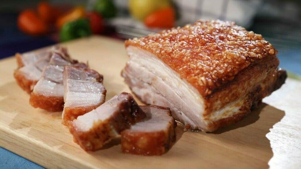 In der thailändischen Küche wird ein Stück Schweinefleisch zubereitet.